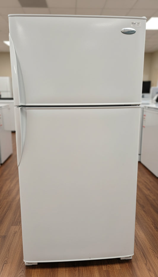White refrigerator in a room with wooden flooring and white walls.