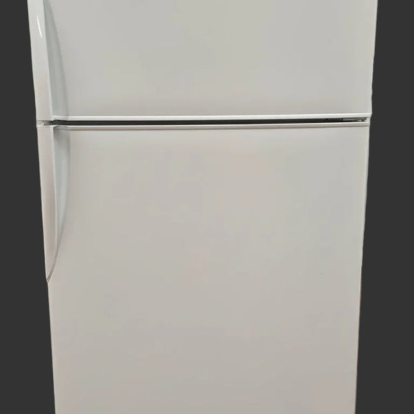 White refrigerator in a room with wooden flooring and white walls.